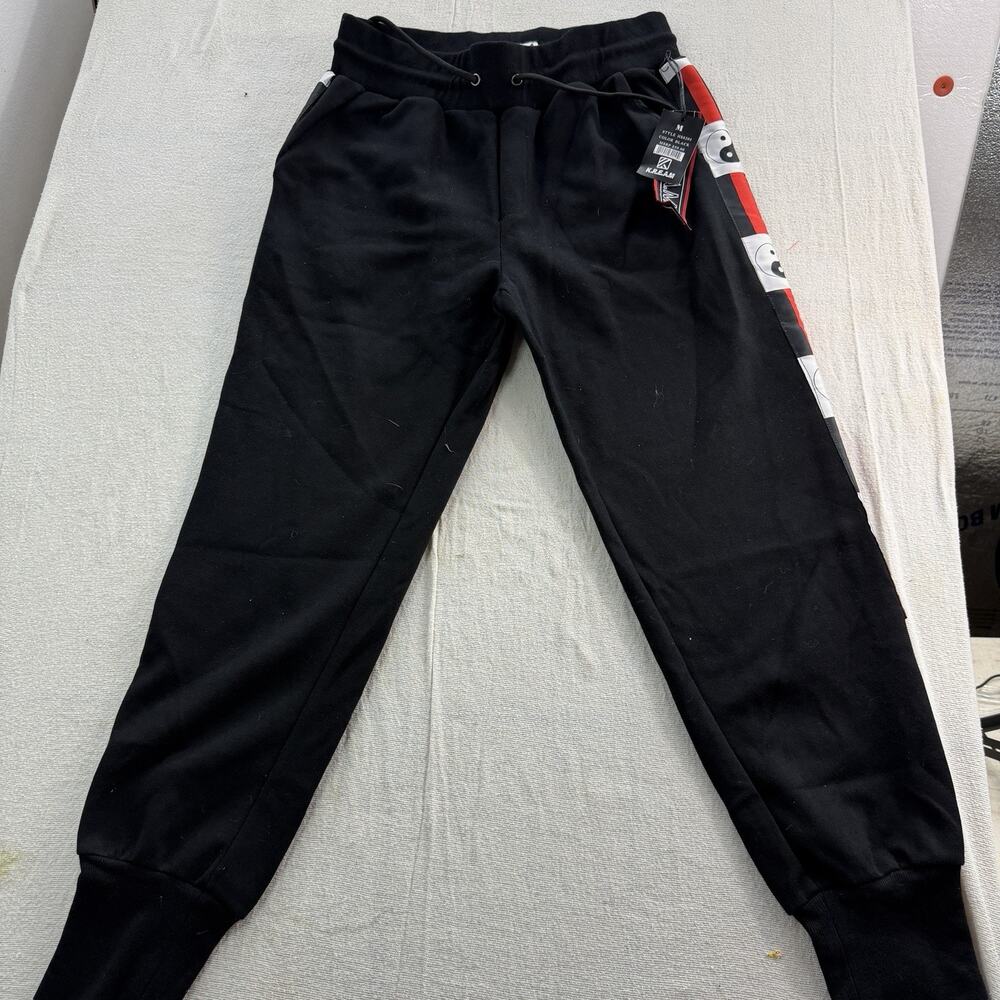 KREAM Track Pants red and white stripe along the sides with a yin-yang design.